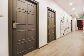 A hallway with two doors, each marked with a number. - Townhouse Meridian Regency (Hyderabad)