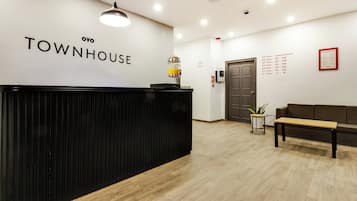 A reception desk with a sign reading 'TOWNHOUSE' and a wall-mounted 'HOUSE RULES' sign listing room numbers and floor assignments.