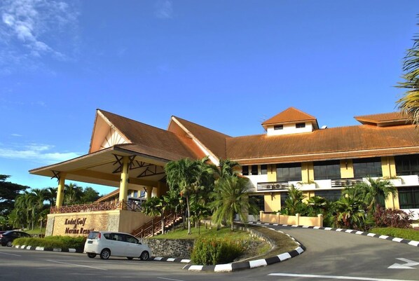 A hotel with a covered entrance, palm trees, and a curved driveway. - Kudat Golf and Marina Resort (Kudat)