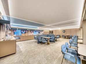 A modern restaurant with a clean, minimalist design, featuring a mix of seating options and a central counter. - Hanting Hotel Xihu Xiebai (Hangzhou)