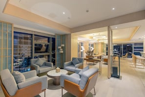 A modern interior with seating areas, a dining space, and a view of the cityscape through large windows. - Argyle Hotel (Honghe)