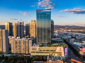 A high-rise hotel with a modern glass facade, surrounded by other high-rise buildings in an urban setting. - Argyle Hotel (Honghe)