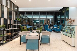 Un interior moderno con asientos, una zona de recepción y una vitrina de vidrio.