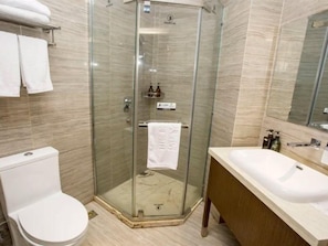 A modern bathroom with a glass-enclosed shower, a white toilet, and a vanity with a sink. - Xiangxie Lidu Hotel (Taizhou)