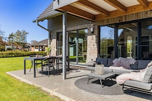 A modern outdoor patio with a dining table, chairs, and a sofa. - Grosse Freiheit – stylish ground-floor apartment, quiet location, sleeps up to 4 (Büsum)