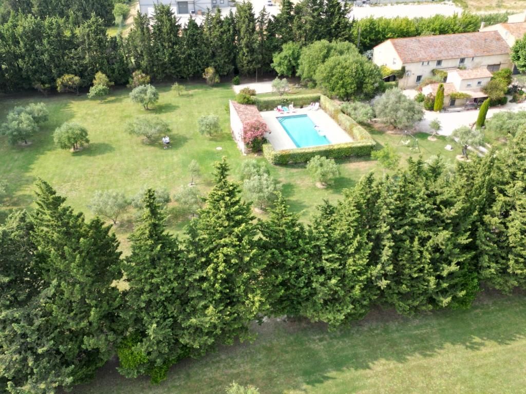 Vista aérea de una propiedad residencial con piscina, rodeada de céspedes y árboles bien cuidados.