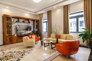 Un salon moderne comprenant un canapé, des fauteuils, une table basse et un meuble décoratif.