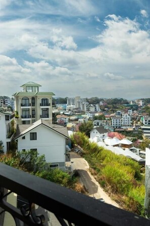 Uma área residencial com uma casa de destaque, com telhado verde e varanda.