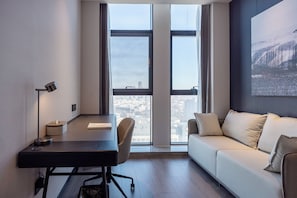 A modern office space with a desk, chair, and a couch.