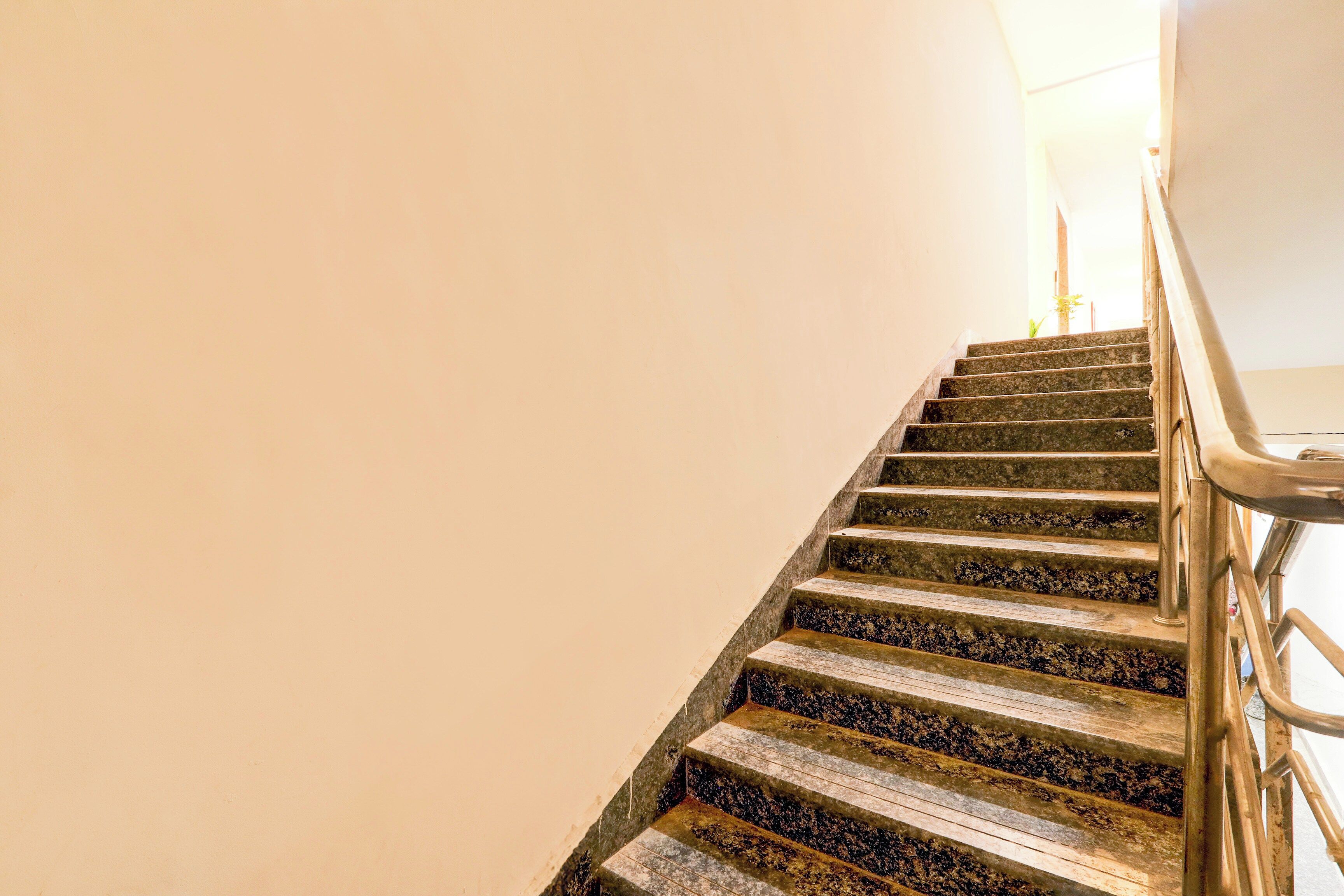 Una escalera con barandilla y una fuente de luz en la parte superior.
