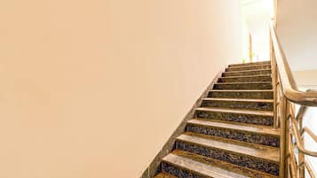 Una escalera con barandilla y una fuente de luz en la parte superior.