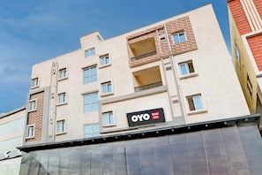 Un immeuble abritant un hôtel à plusieurs étages, avec une enseigne indiquant « OYO Hotel Vyb ».
