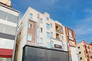 Hotel com vários andares, fachada moderna, varandas e um letreiro de hotel em destaque.