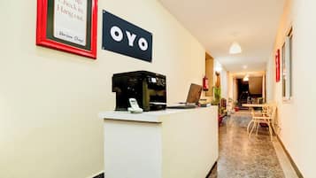 A hotel reception area with a sign that reads 'OYO' and a framed sign above it that says 'Turn up. Check in. Hang out.'