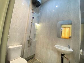 Een badkamer met een toilet, douche en wastafel.