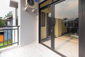 Entrada de un edificio con puerta de vidrio, una manija negra y un ventilador de techo.