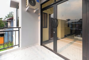 Entrada de un edificio con puerta de vidrio, una manija negra y un ventilador de techo.