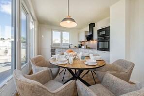 Una cocina moderna con comedor, ventanas amplias y vistas a la ciudad.