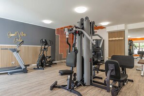 Ein Fitnessstudio mit Laufbändern, Krafttrainingsgeräten und einer Wand mit motivierenden Sprüchen.