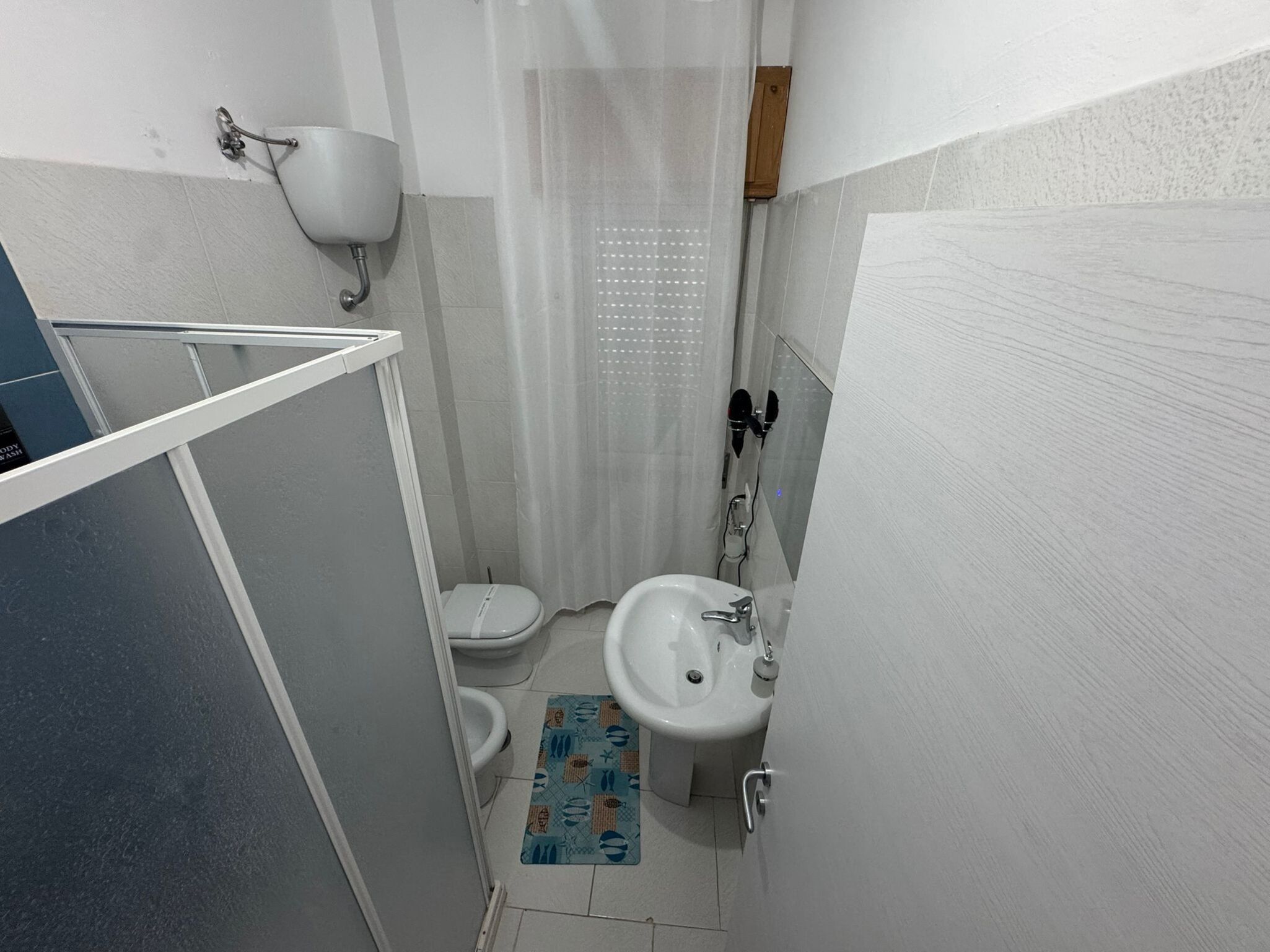 Une petite salle de bain avec des toilettes, un lavabo et un rideau de douche.
