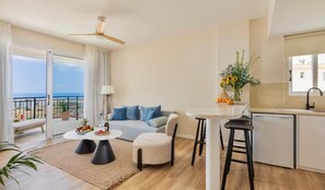 A modern living room with a sofa, a dining table, and a kitchen area. - LiBa (Chlorakas)
