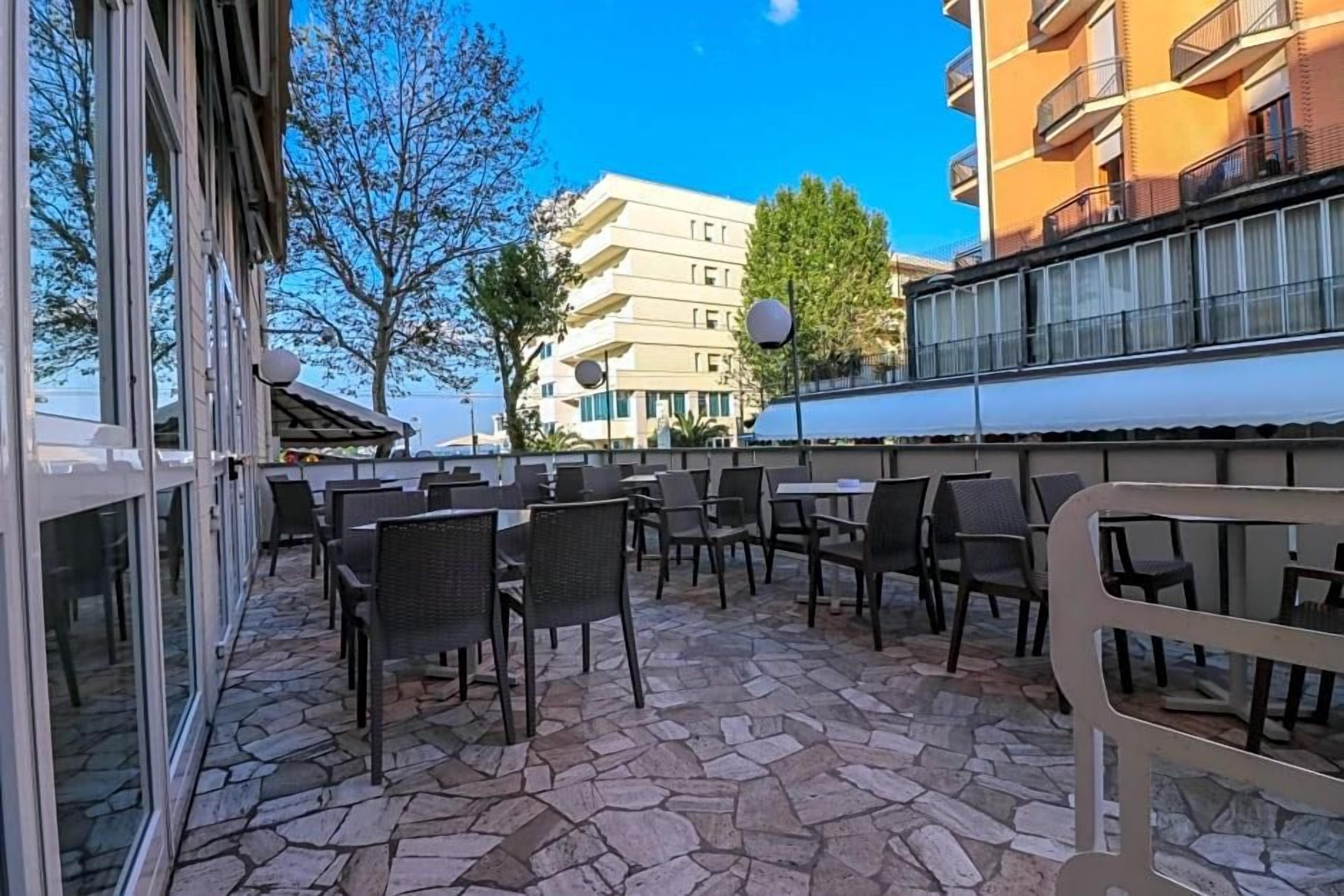 Eine Terrasse im Freien mit Steinböden und Korbmöbeln.