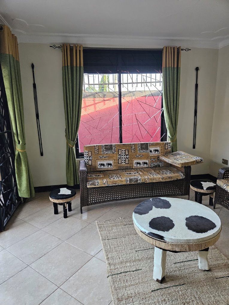 A room with a sofa, a round table, and a patterned rug.