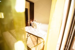 A hotel room with a bed, a door, and a window. - Sigona Golf Club (Kikuyu)