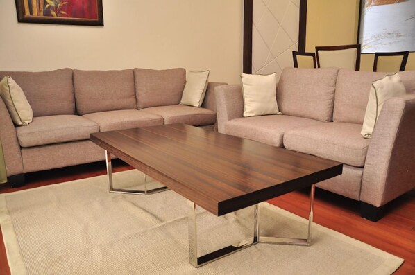 A living room with two sofas, a coffee table, and a rug. - Sigona Golf Club (Kikuyu)