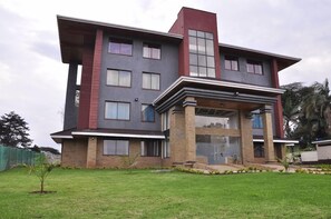 A modern two-story building with a flat roof, large windows, and a covered entrance area. - Sigona Golf Club (Kikuyu)