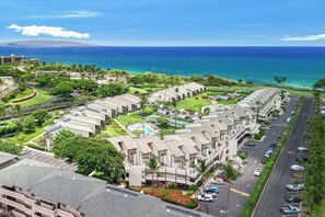 A resort with multiple-story buildings, a swimming pool, and a view of the ocean. - Hale Kamaole 244 - Modern Suite next to Beach (Kihei)