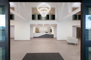Eine geräumige Lobby mit einer Kronleuchter, einem Empfangsbereich und einer Sitzecke.