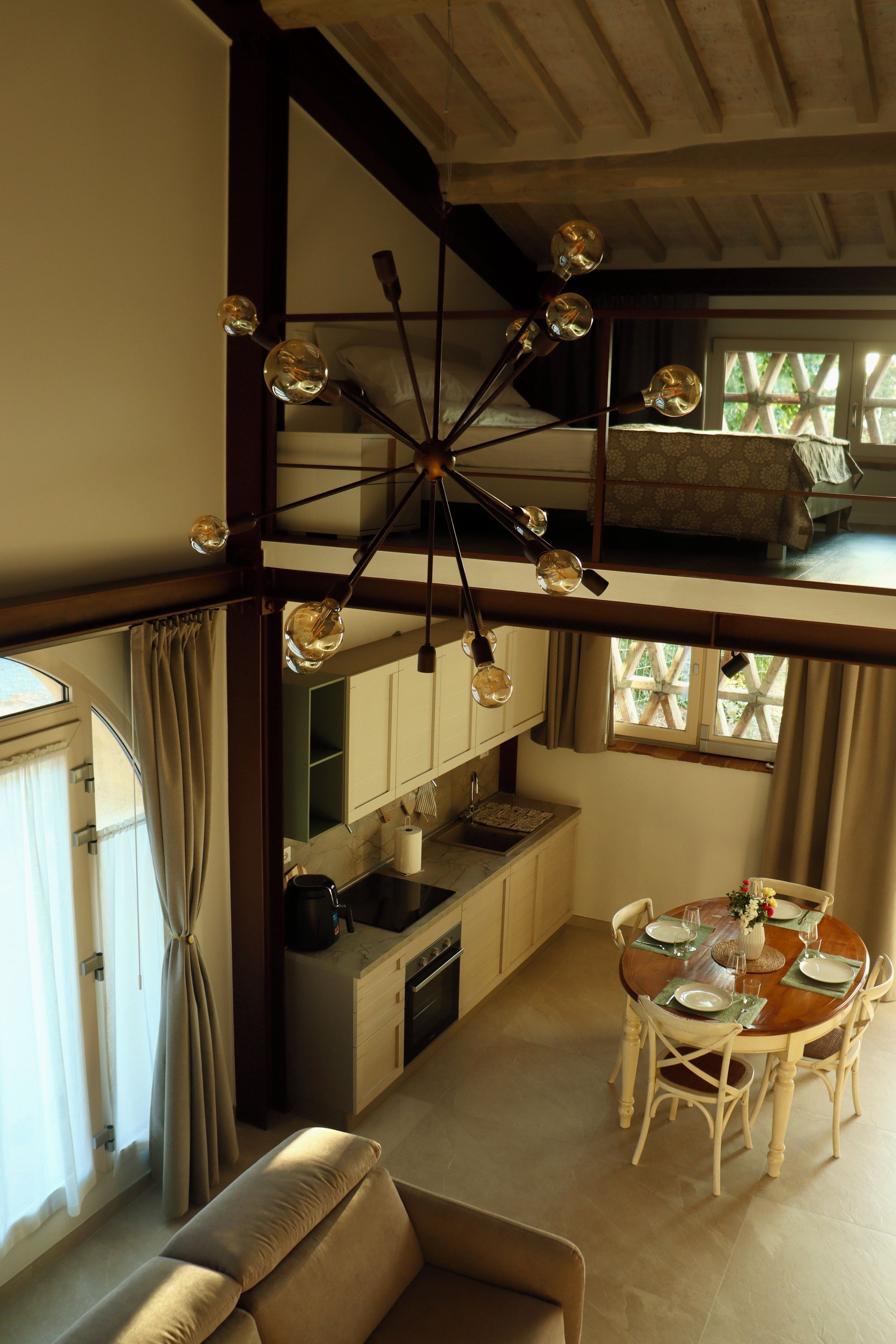 Una habitación con techos altos, una litera, un comedor con mesa para cuatro personas y una cocina con electrodomésticos modernos.