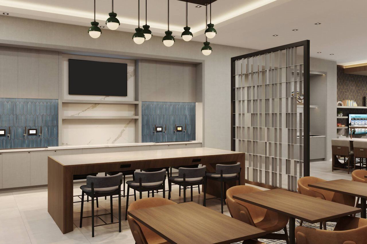 A modern kitchen with a large island, bar stools, and pendant lighting.