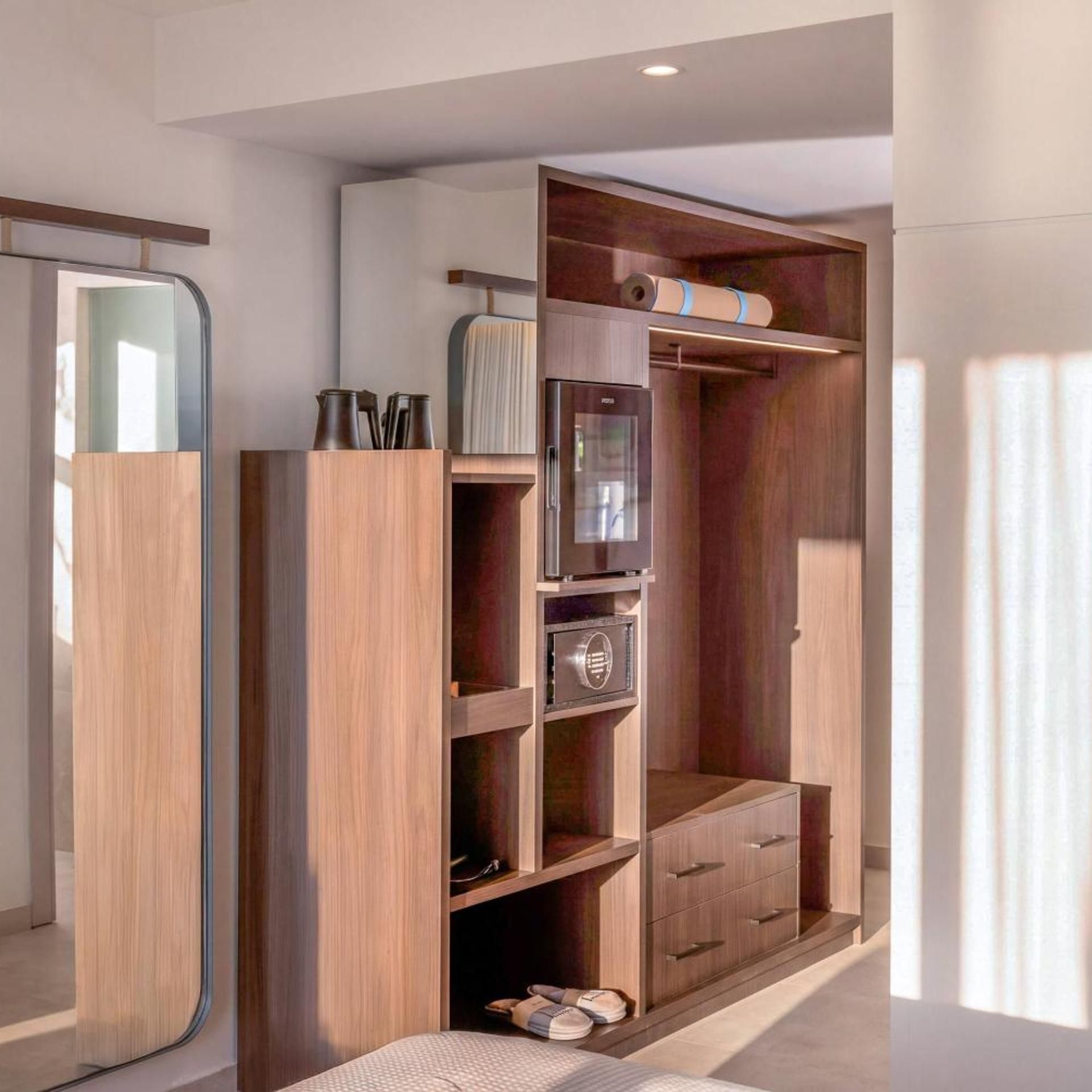 A walk-in closet with a built-in wardrobe, a minibar, and a shoe rack.