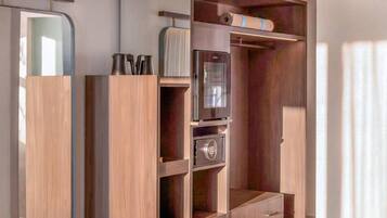 A walk-in closet with a built-in wardrobe, a minibar, and a shoe rack.