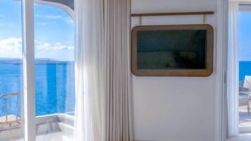 Una habitación con un ventanal grande, una puerta que da a un espacio exterior y una pantalla montada.