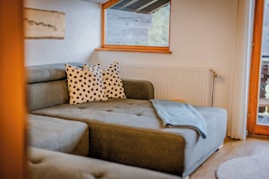 Quarto aconchegante com sofá, janela e radiador.