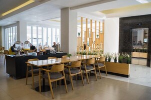 Un comedor moderno con una isla central, sillas de madera y una barra.
