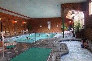 An indoor swimming pool with a hot tub, lounge chairs, and a wooden interior. - Multi-level 2 bedroom condo near Loon Mt. #321 (Lincoln)