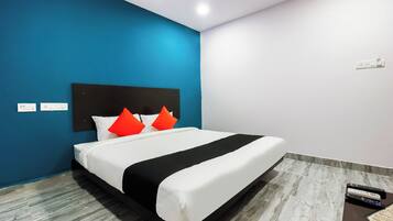 Une chambre d’hôtel équipée d’un lit, d’un ventilateur de plafond, d’une prise électrique et d’un sol à motifs de marbre.