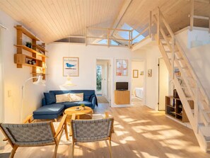 A spacious living area with a blue sofa, wooden chairs, a coffee table, and a staircase. - "Herdina" - 300m from the sea by Interhome (Grenaa)