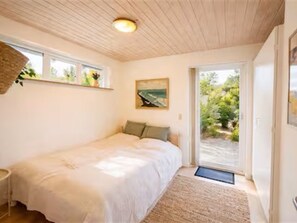 A bedroom with a bed, a window, a door leading outside, and a ceiling light. - "Herdina" - 300m from the sea by Interhome (Grenaa)