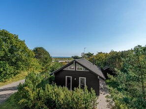A small cabin with a sloped roof, surrounded by dense greenery and a clear view of the sea. - "Herdina" - 300m from the sea by Interhome (Grenaa)