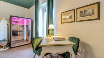 Une pièce comprenant une table à manger, des chaises, une lampe, un miroir et deux tableaux encadrés accrochés au mur.