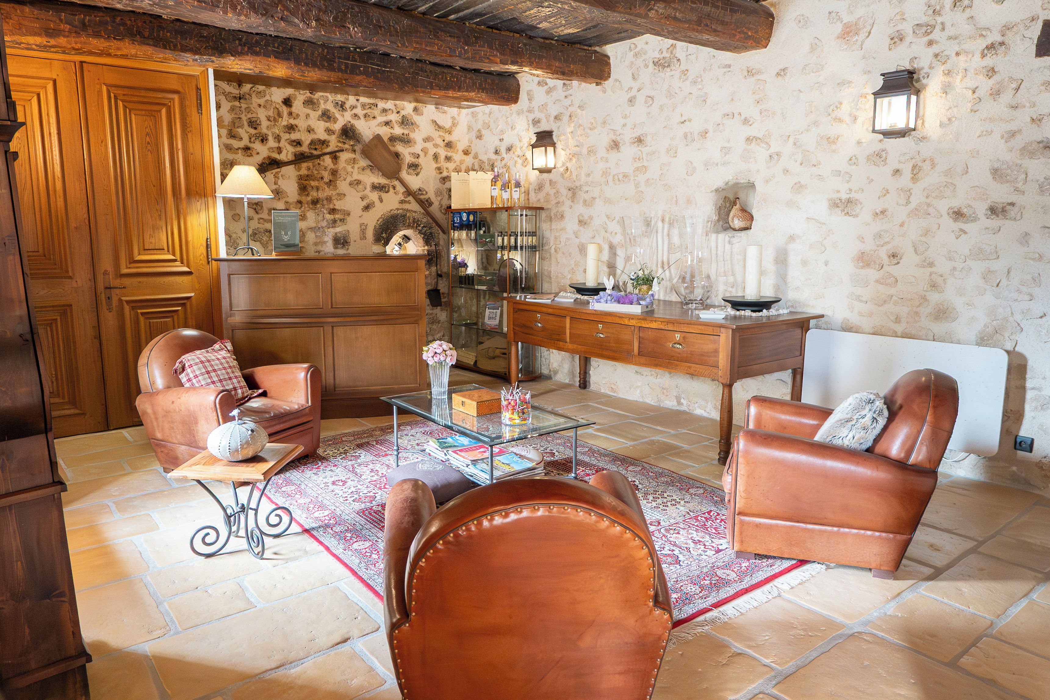 Una sala de estar acogedora con sillones de cuero, una mesa de centro de vidrio y un aparador de madera.
