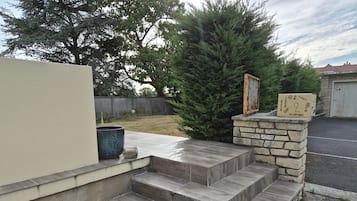 A set of outdoor steps leading to a garage, with a mailbox and a number sign on the right.