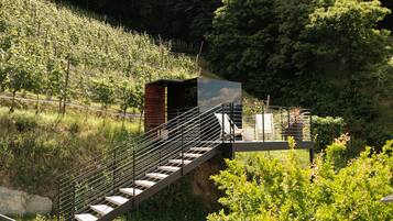 A staircase leading to a covered area with a view of a forested hillside.