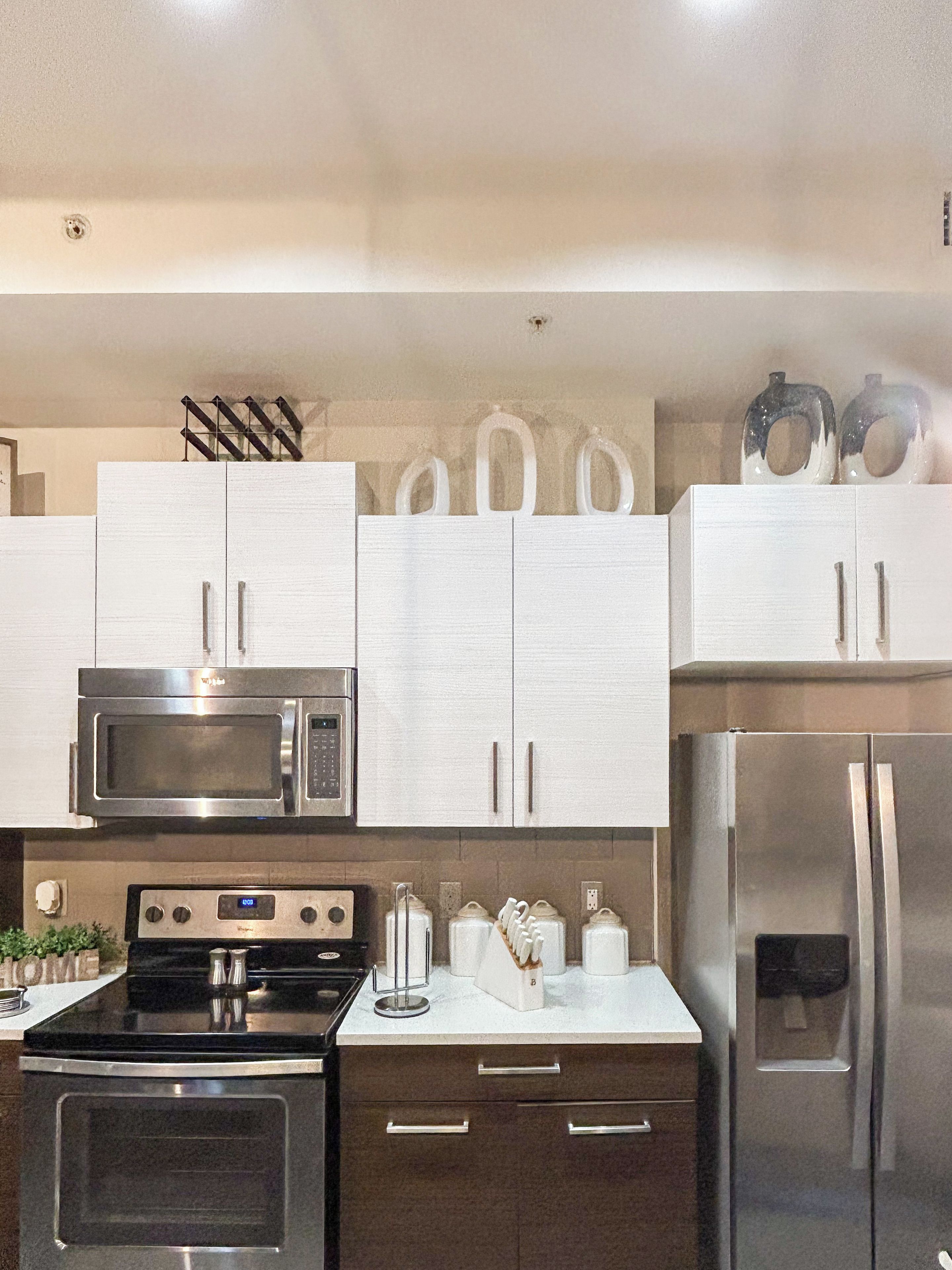 Een moderne keuken met roestvrijstalen apparatuur, witte kasten en een strak design.