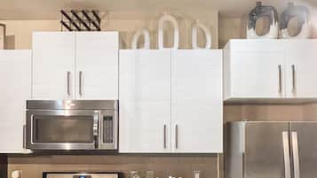 Een moderne keuken met roestvrijstalen apparatuur, witte kasten en een strak design.
